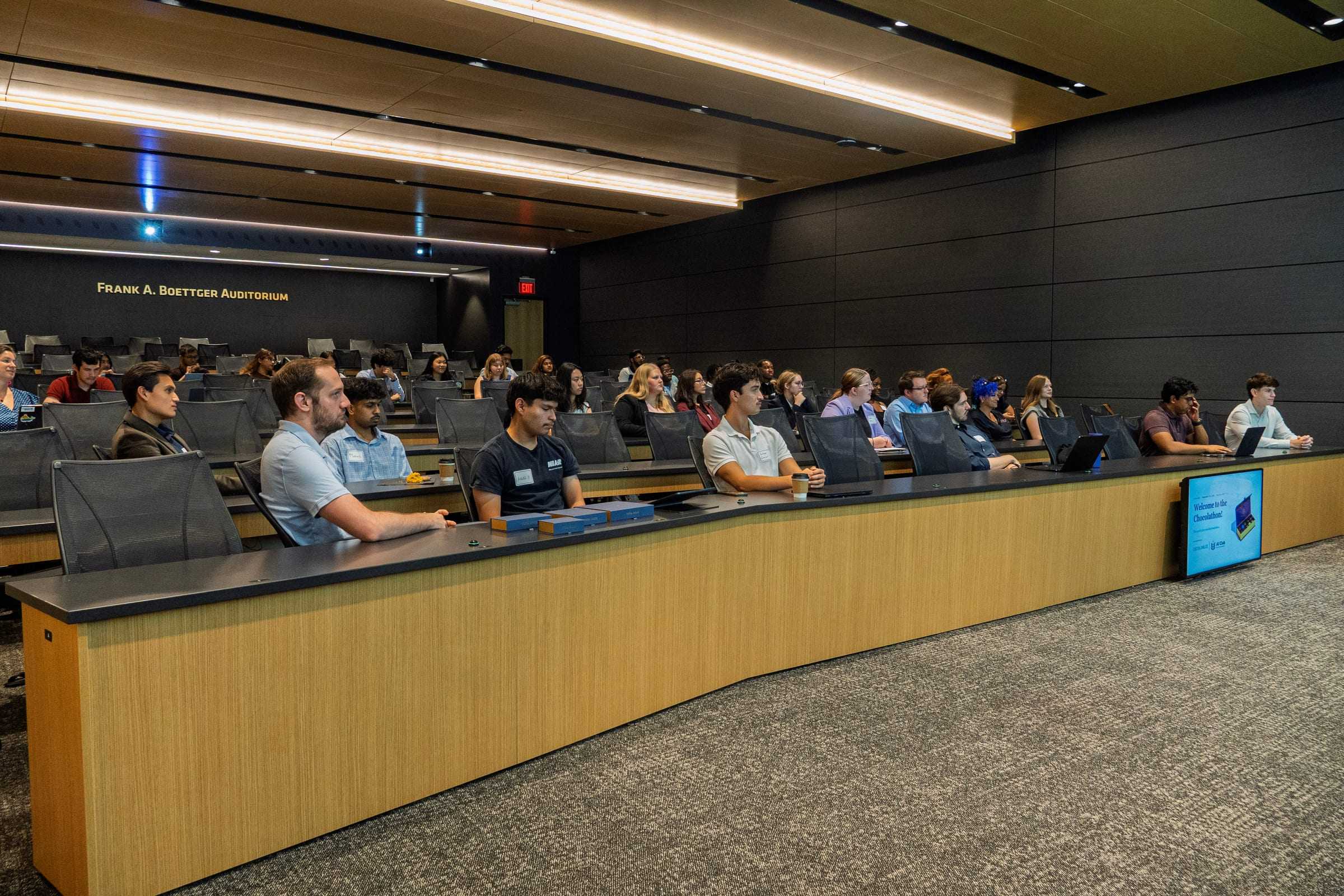 Chocolathon participants fill the rows of the Frank A. Boettger Auditorium, with laptops and boxes on the desks.