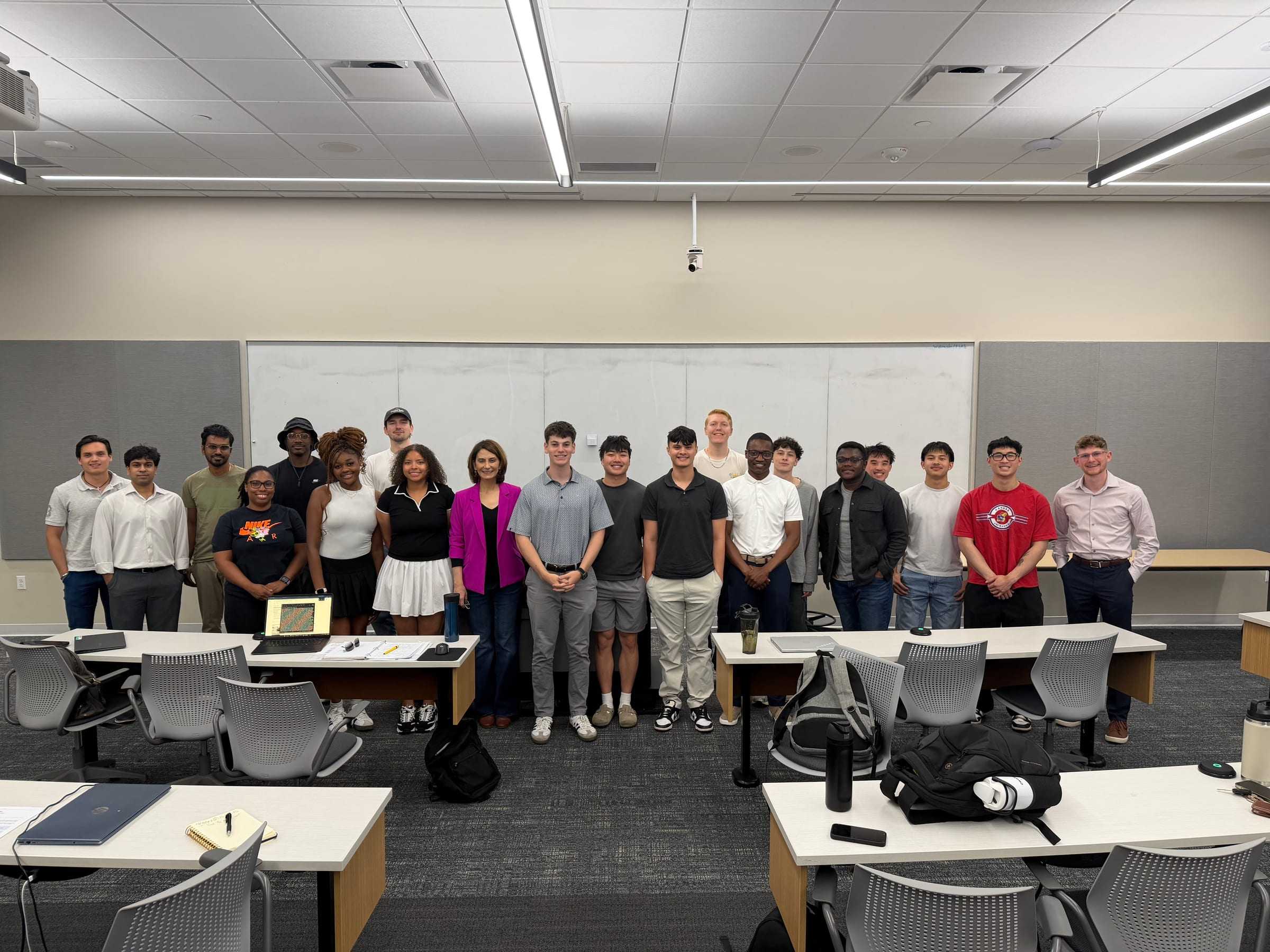 About 20 people pose at the front of a Wichita State classroom after an AI Club meeting.