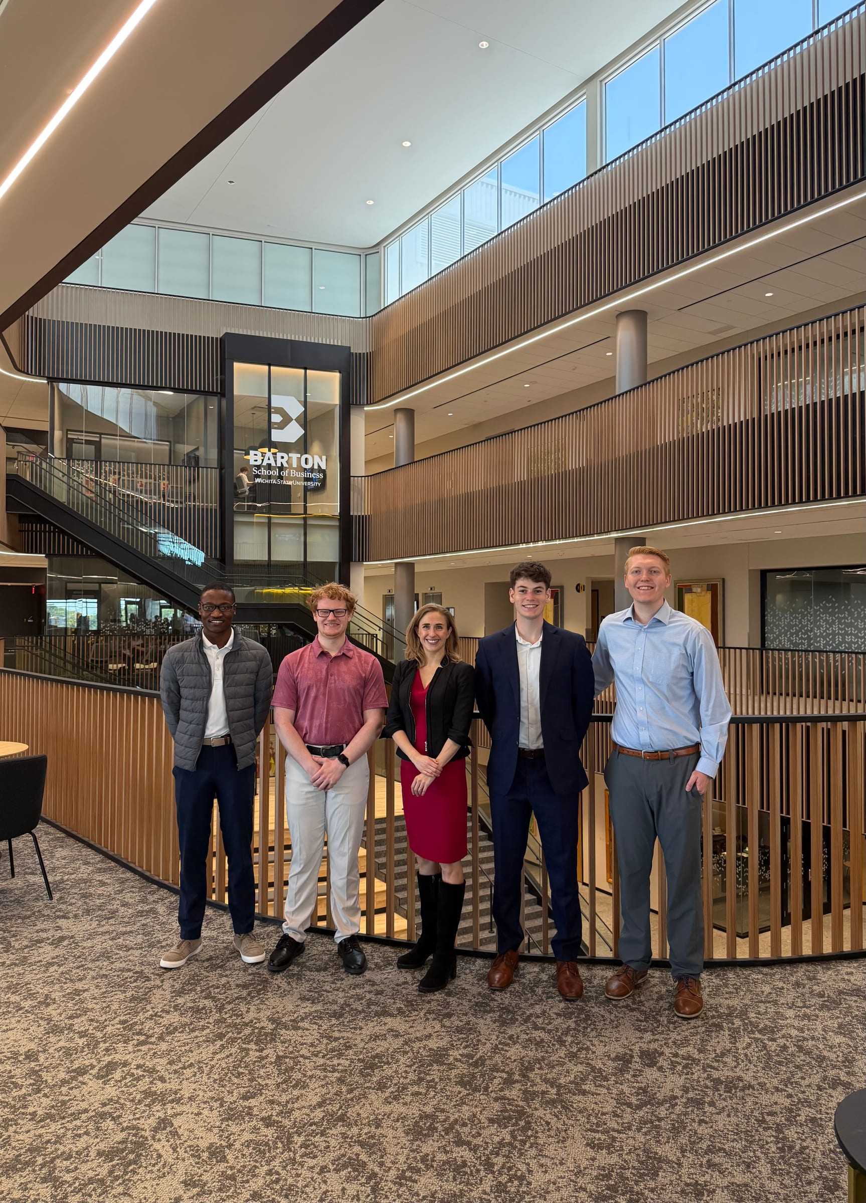 Lauren Dunford, CEO and co-founder of Guidewheel, stands with four AI Club members on a balcony of the Barton School of Business atrium.